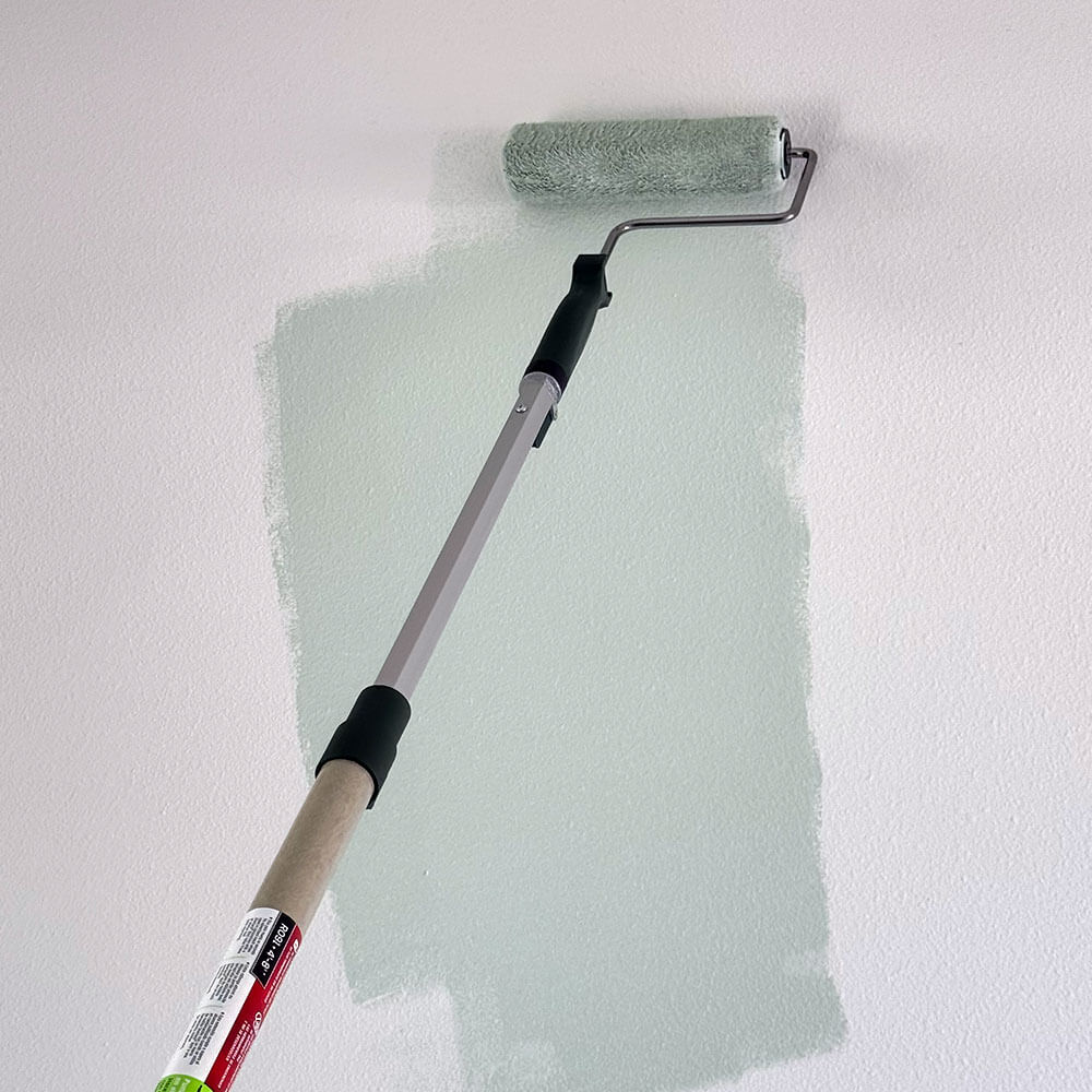 Loading paint on to the paint roller on the wall