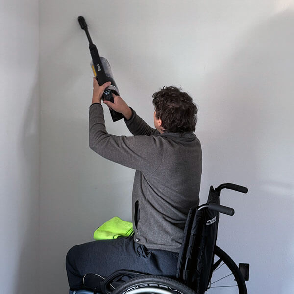 Vacuuming spider webs off the wall corner